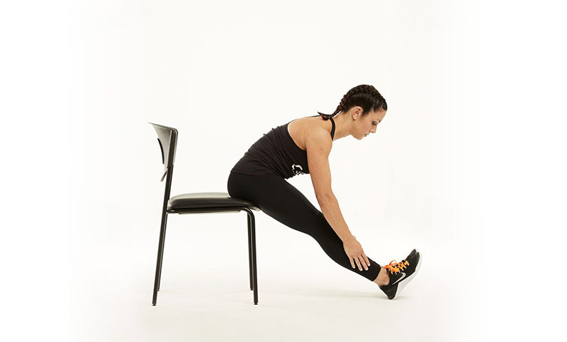 A woman stretching legs on a chair